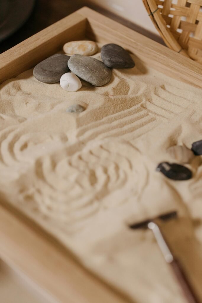 Minimalist zen garden with stones on smooth sand, showcasing serenity and Japanese aesthetics.